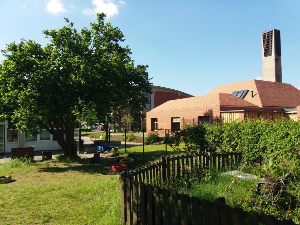 Foto: Blick von der rückwärtigen Grünfläche auf Plangrundstück und Gemeindezentrum