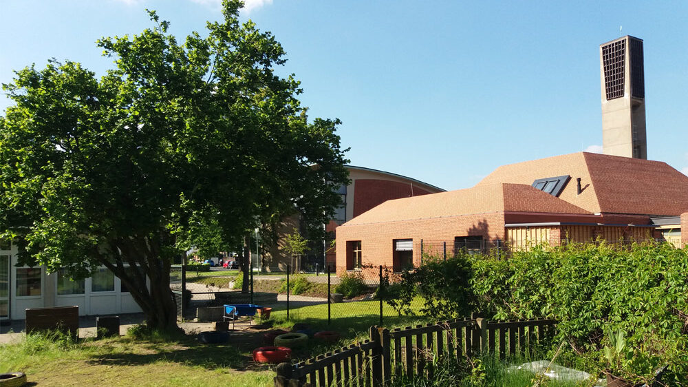 Foto: Blick von der rückwärtigen Grünfläche auf Plangrundstück und Gemeindezentrum