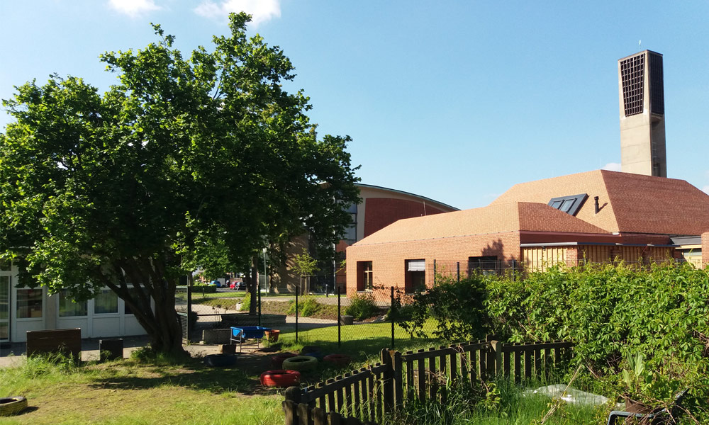 Foto: Blick von der rückwärtigen Grünfläche auf Plangrundstück und Gemeindezentrum